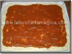 Distribuire la salsa di pomodoro sulla pizza