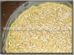 Cospargere i pinoli sulla torta 