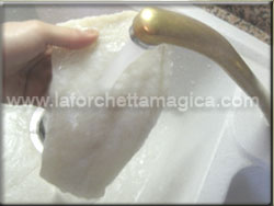 Lavare il baccal sotto l'acqua corrente per eliminare il sale