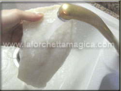 Lavare il baccal sotto l'acqua corrente per eliminare il sale