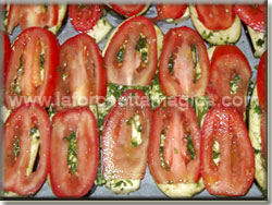 Disporre i pomodori a fette sulle melanzane